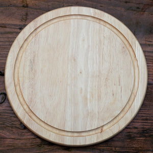 Round wooden cutting board on a rustic wooden surface