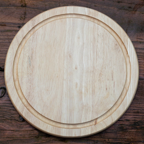 Round wooden cutting board on a rustic wooden surface