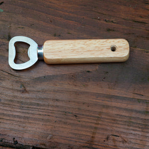 Bottle opener with wooden handle on a wooden surface